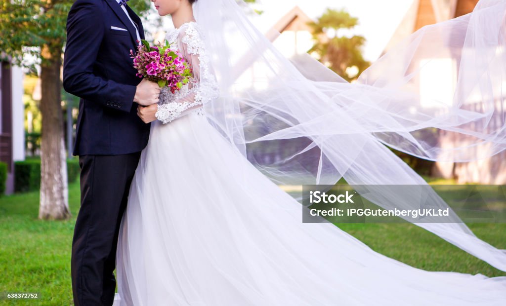 Seitenansicht des Hochzeitspaares, das auf Rasen steht - Lizenzfrei Braut Stock-Foto