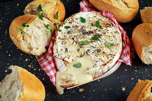 Homemade Baked Camembert cheese with thyme and fresh bread.