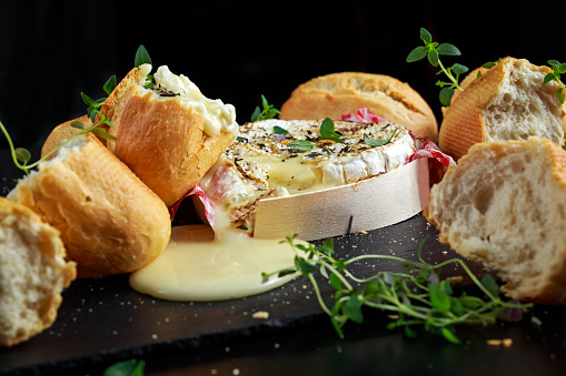 Homemade Baked Camembert cheese with thyme and fresh bread.