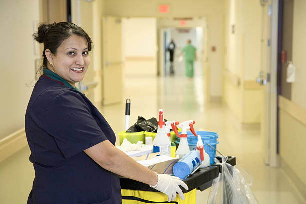 Custodian janitor in hospital hallway with cart Custodian janitor in hospital hallway with cart cleaning equipment photos stock pictures, royalty-free photos & images
