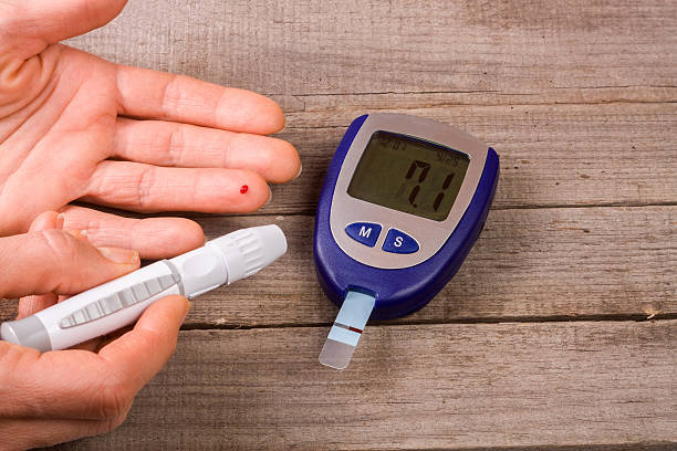 istock blood glucose meter with a hand on an old wooden 638376244