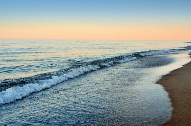 Sea waves wash the beach against  backdrop of evening