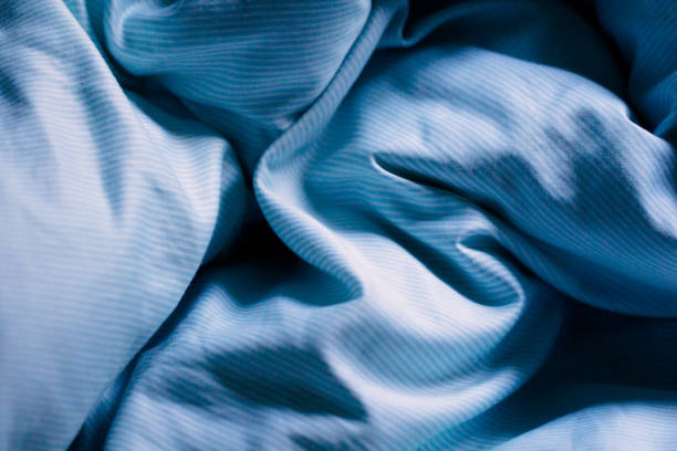 istock Wrinkled blue bed sheets on a morning as a background 638377148