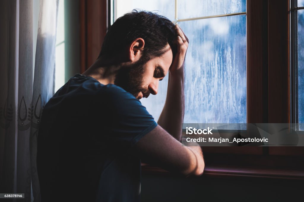 Joven triste loco sentado en arrepentimiento - Foto de stock de Hombres libre de derechos