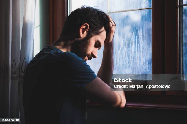 Young Sad Mad Sitting In Regret Stock Photo - Download Image Now - Men, Sadness, Depression - Sadness