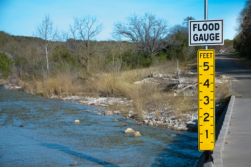 Flood gauge located on roadside beside a small river in Texas, USA