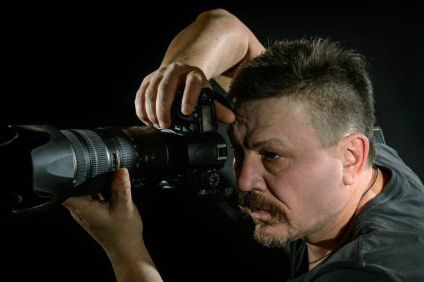 istock portrait photographer with a camera on  black background 638378998