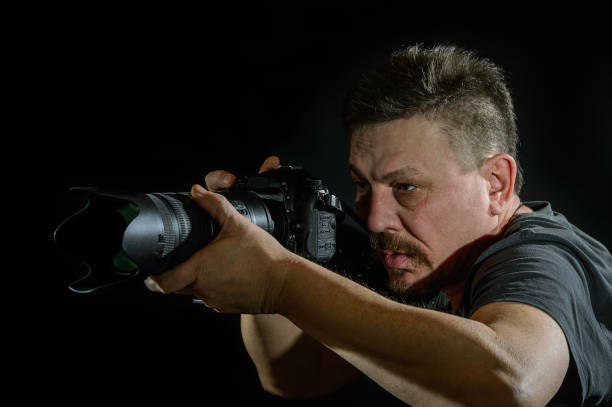 istock portrait photographer with a camera on  black background 638379050