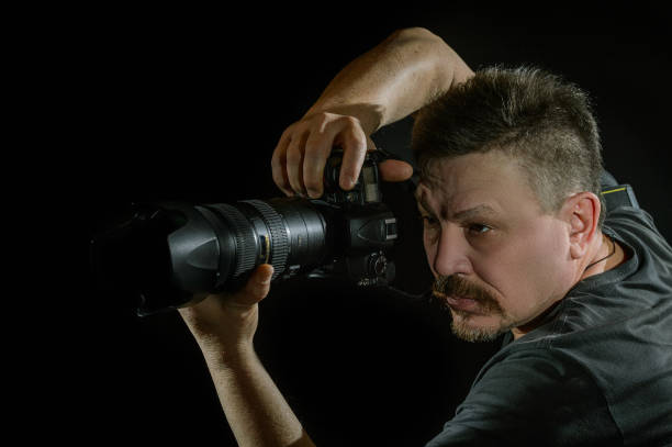 istock portrait photographer with a camera on  black background 638379094