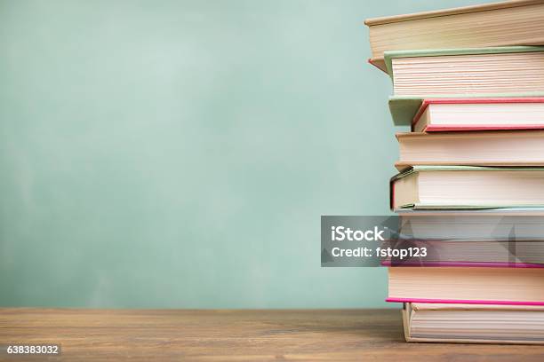 Textbooks Stacked On School Desk With Chalkboard Background Stock Photo - Download Image Now