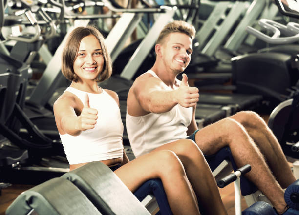 istock man and woman making sit ups together using machine 638386396