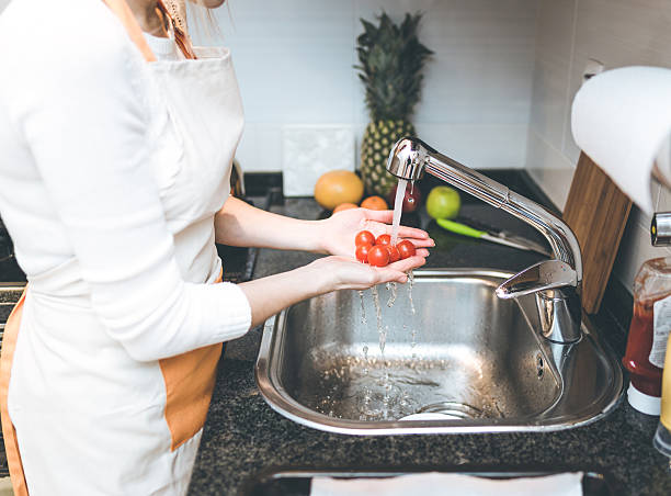 istock Woman in the kitchen wash vegetables 638386950