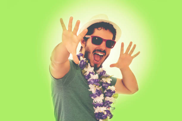 Man celebrating carnival party. Wearing sunglasses, hat and flower necklace. Color filter and copy space.
