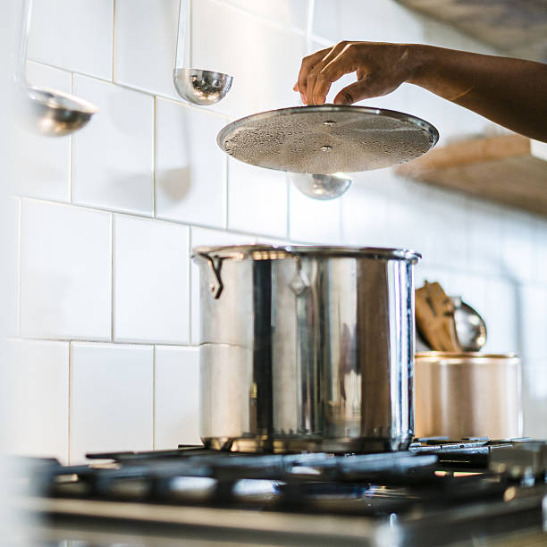 Young pretty black, afro-american, girl make a soup in the pot at the domestic kitchen.