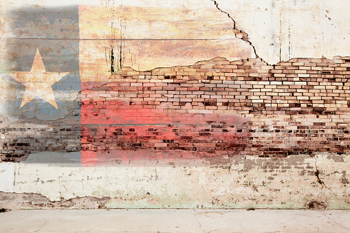 Texas flag painted on grunge brick wall.  Old peeling paint, rustic, weathered. Red, white, blue with one white star.  Great Texas background.