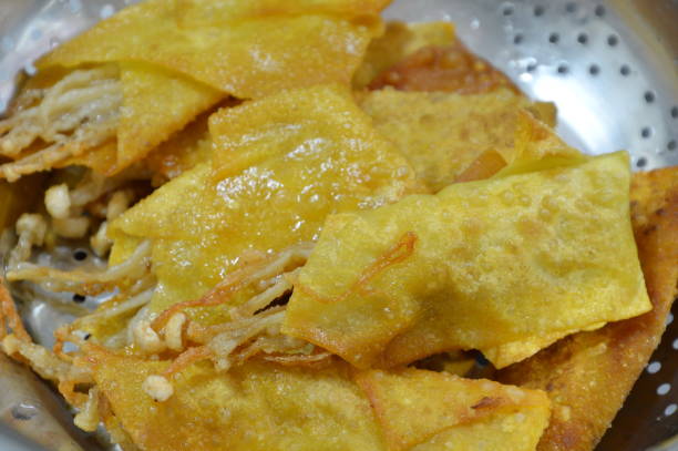 istock deep fried needle mushroom wrap in dumpling flour on sieve 638395964