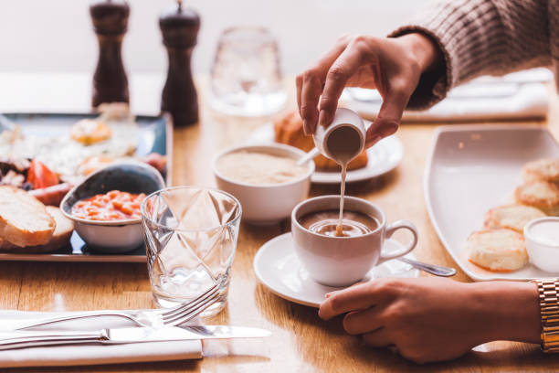 istock Girl pouring milk in coffee at breakfast 638396328