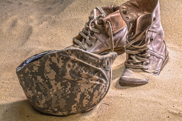 istock soldier hat  boots and sand glass in the desert 638399534