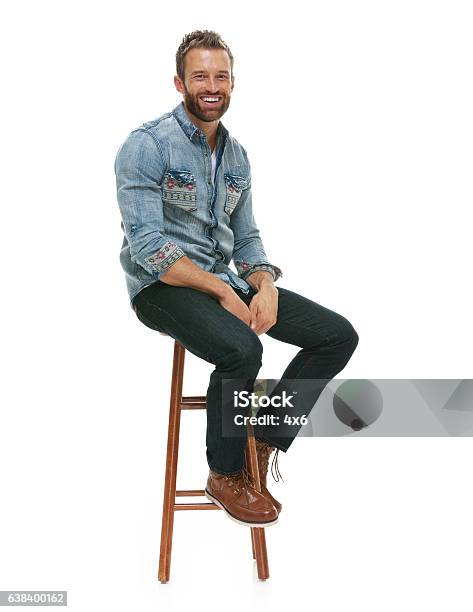 Cheerful Man Sitting On Stool Stock Photo - Download Image Now - Sitting, Men, Stool