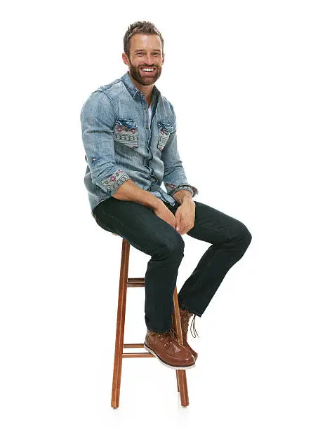 Cheerful man sitting on stool