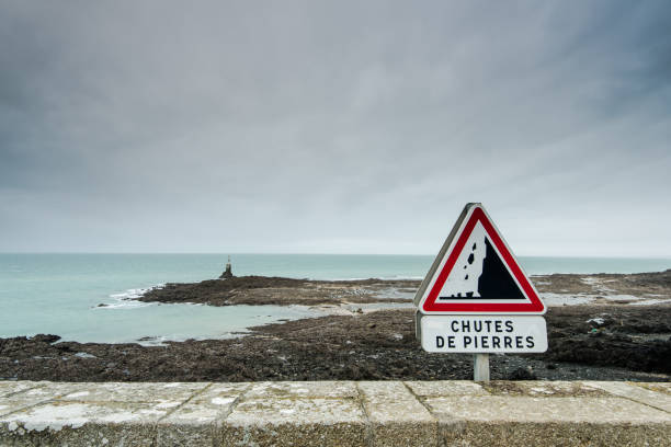 Road sign warning of danger cliffs in France on the edge of coast.
