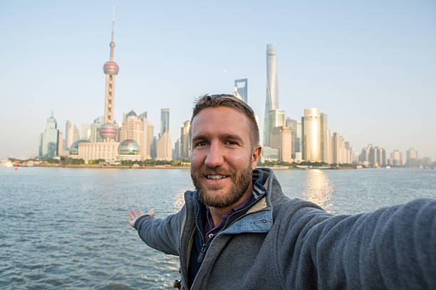 istock Young man taking selfie portrait in Shanghai, China 638401234