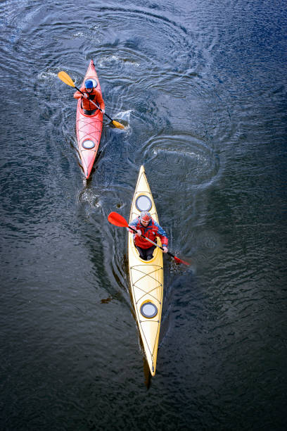 Rear view of woman paddling on red canoe in peaceful blue lagoon in Mexico