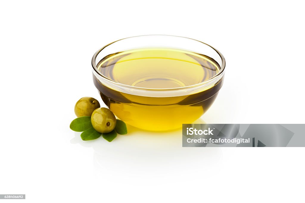 Olive oil Olive oil and green olives with leaves in glass bowl sitting on reflective white backdrop.  DSRL studio photo taken with Canon EOS 5D Mk II and Canon EF 70-200mm f/2.8L IS II USM Telephoto Zoom Lens Olive Oil Stock Photo