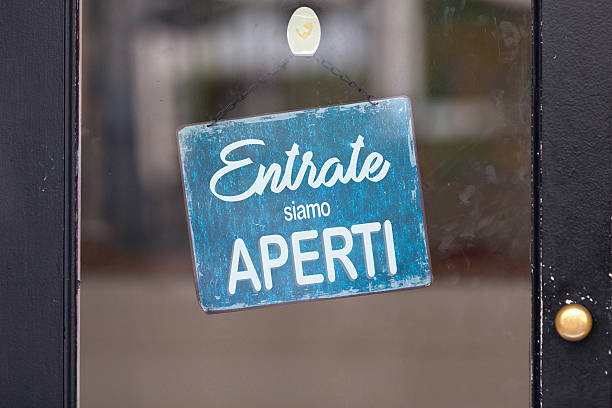 Italian open sign in a window Sign attached to a glass door saying in Italian “Entrate, siamo aperti”, meaning in english “Come in, we’re open”. italian language stock pictures, royalty-free photos & images