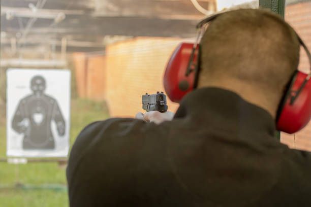 disparar con una pistola. hombre disparando pistola en campo de tiro. - armed forces human hand rifle bullet fotografías e imágenes de stock