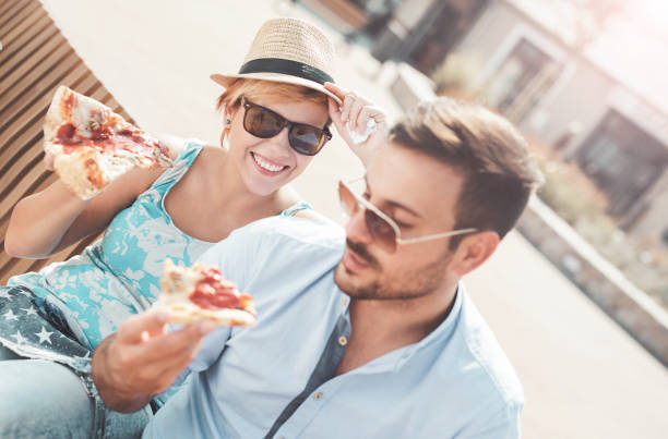 istock Couple eating pizza outdoors 638412568