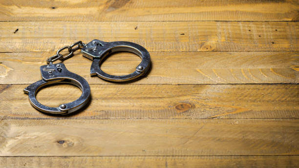 istock Handcuffs on a wooden table 638415064