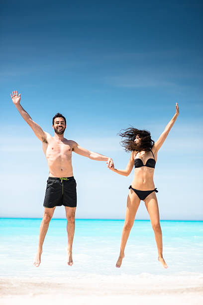 istock Happiness couple at the seaside jumping on the beach 638418064