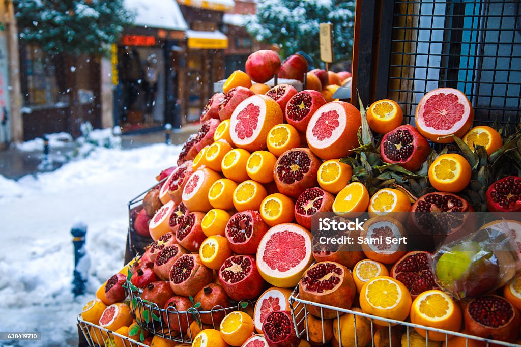 Mix tropic citrus fruits at street market in winter time Healthy winter produce pomegranates, oranges and grapefruits waiting for make juice recipes at the street market in snowy winter day Winter Stock Photo