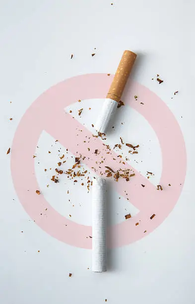broken cigarette on white background with stop sign