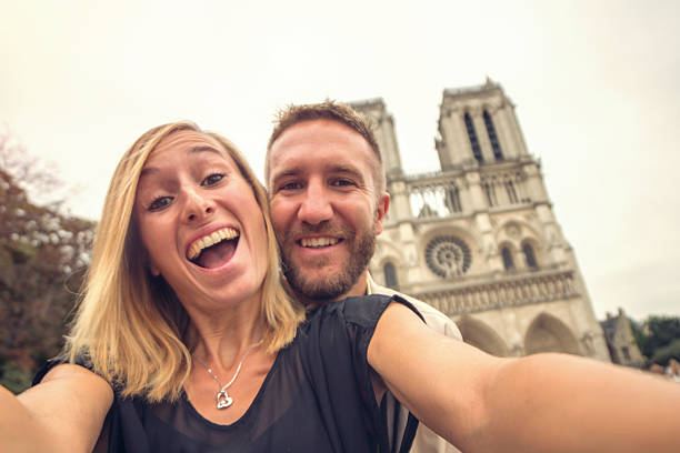 giovane coppia che si fa selfie con notre dame de paris, francia - paris france heterosexual couple couple french culture foto e immagini stock
