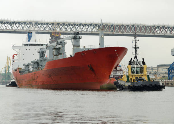 Tug pulling a tanker. Tugboat pulling a large tanker from the port after it is downloaded. bilge of ship stock pictures, royalty-free photos & images