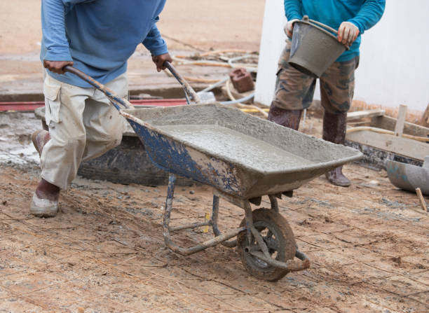 istock worker pushing barrow with wet cement to pouring concrete floor 638425744
