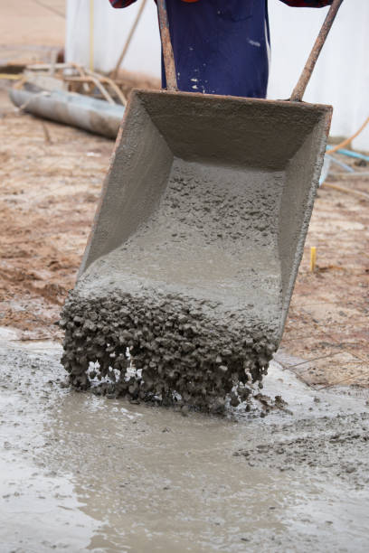 istock worker pouring cement from cart to floor 638425820