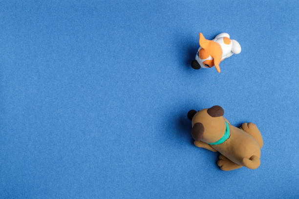 istock Two dogs from plasticine on a blue background sideways 638427066