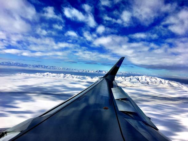 airplane wing over mountains stock photo