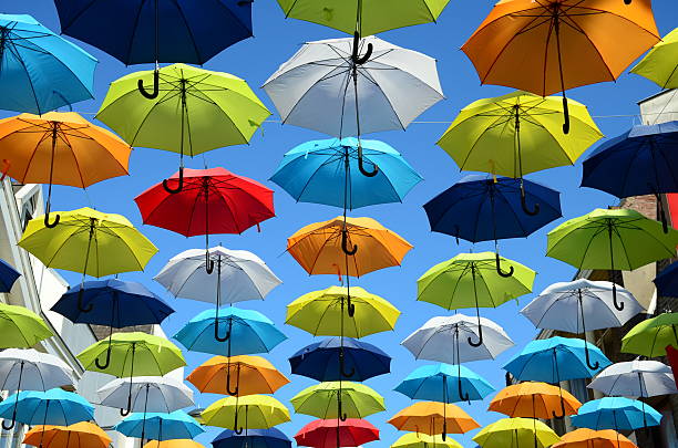 colorido fondo de paraguas. paraguas de colores en el cielo soleado. decoración de calles. - rainbow umbrella descriptive color multi colored fotografías e imágenes de stock