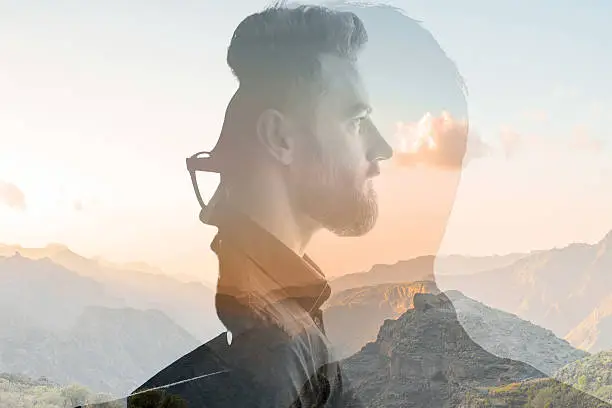 Triple exposure portrait of a businessman combinated with beautiful mountain landscape on the sunset