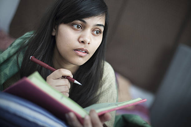 Girl student studying in bed at home.