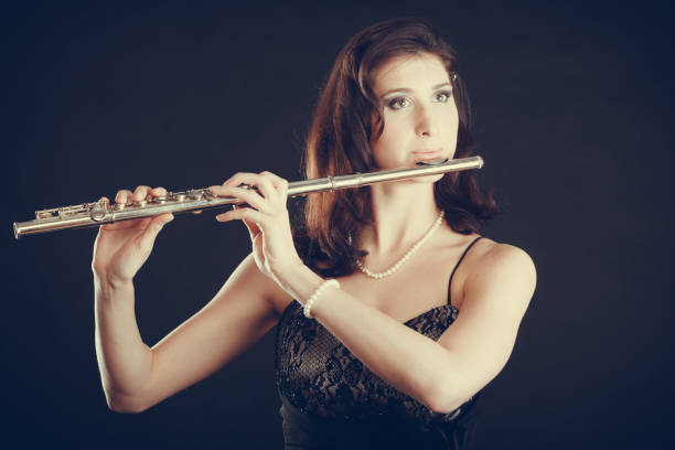 istock Woman playing transverse flute on black. 638442382