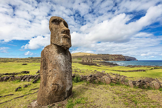 Ahu Tongariki Travelling Moai Easter Island Statue Rapa Nui Ahu Tongariki Easter Island Moai Statues under sunny deep blue summer sky. The "Traveling Moai" in the foreground. The 'Travelling Moai', so called as it has wandered the most of any Moai on the island. After first 'walking' from the quarry at Rano Raraku, it has been to Japan for a world fair, come back, and has been used in 'walking' experiments by Thor Heyerdahl to determine how the inhabitants originally moved the Moai.Ahu Tongariki, Rapa Nui National Park, Hanga Roa, Easter Island, Chile. easter island stock pictures, royalty-free photos & images
