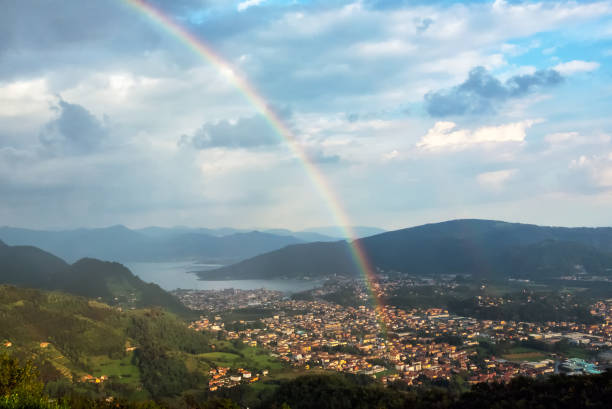 istock Long rainbow over town and hills 638447052