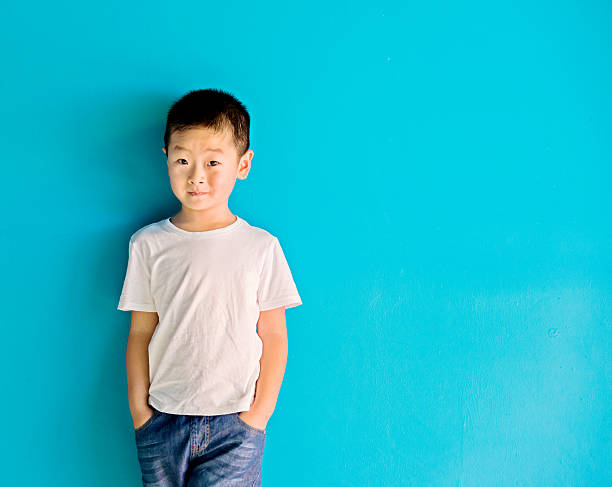 chinês menino contra a parede - child little boys isolated standing - fotografias e filmes do acervo