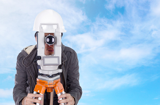 engineer working with survey equipment theodolite with blue sky background