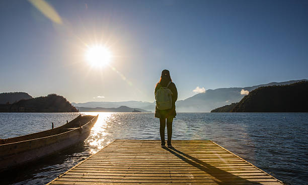 istock woman standing on pier by the lake 638451496